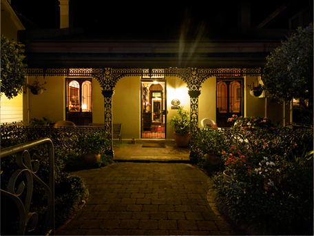 The front garden path and verandah lit at night