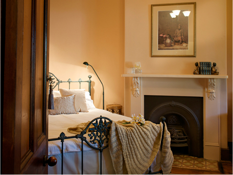 Guest bedroom with iron bedstead and original fireplace